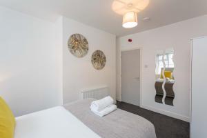 ein weißes Schlafzimmer mit einem Bett und einem Fenster in der Unterkunft Cherry Property - Pineapple Suite in Blackpool