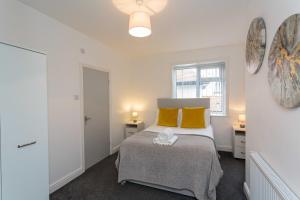 a bedroom with a bed with yellow pillows at Cherry Property - Pineapple Suite in Blackpool