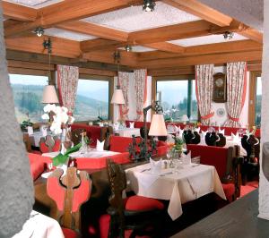 a dining room with tables and red chairs at Höhenhotel & Restaurant Kalikutt in Oppenau