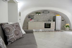 een woonkamer met een bank en een keuken bij Montesantogroup Apartments in Napels