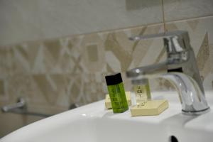 een wastafel met een kraan en twee flessen zeep bij Montesantogroup Apartments in Napels +48 foto's