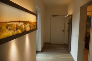 a hallway with a painting on the wall at Meyn's Apartments & Hotel in Soltau