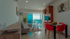 sala de estar con sofá y mesa con sillas rojas en Apartamento Vista Mar 1707, en Cartagena de Indias