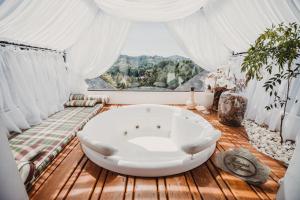 a bath tub in a room with a window at Chateau La Villette in Campos do Jordão