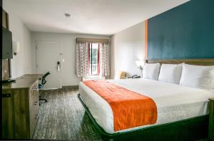 a hotel room with a large bed and a window at Jubilee Inn in Biloxi