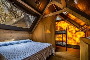 a bedroom in a tree house with a bed in it at Camping Internazionale Etruria in Castiglione della Pescaia