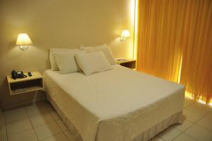
A bed or beds in a room at Aram Ouro Branco Hotel
