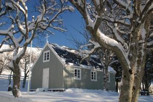 ein graues Haus mit Schnee auf dem Dach in der Unterkunft Stafafell Cottages in Stafafell