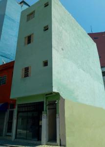a white building with a door in front of it at Pousada Brasil - Self Check-in in Aparecida