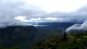 a view of a valley in the mountains with clouds at Acropole Delphi City Hotel in Delphi