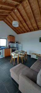 a living room with a table and chairs and a kitchen at Sara Village in São Roque do Pico