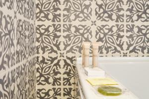 a bathroom with a black and white patterned wall at Sintra Boutique Hotel in Sintra