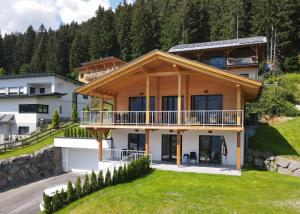 a house in the mountains with a porch and balcony at Chalet Rotheheim in Kirchbach