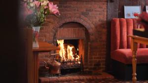 a brick fireplace with a fire in it at The Five Bells, Eastry in Sandwich