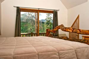 - une chambre avec un lit et une grande fenêtre dans l'établissement Hideaway Cabin, à Breckenridge