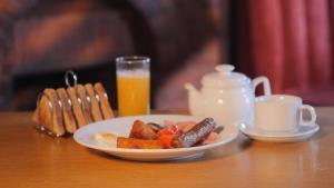 un piatto di cibo su un tavolo con un bicchiere di succo d'arancia di The Five Bells, Eastry a Sandwich