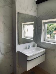 ein Bad mit einem Waschbecken und einem Spiegel in der Unterkunft Violet Apartment by Alex Rafael in Zagreb