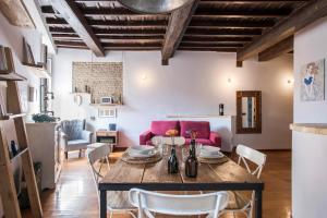 a living room with a wooden table and pink couch at AndreaSuite - Piazza Navona in Rome