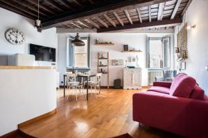 Una sala de estar con un sofá rojo y una mesa. en AndreaSuite - Piazza Navona, en Roma