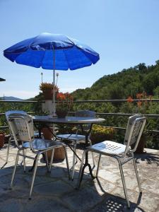 una mesa, dos sillas y una sombrilla en B&B collina e mare, en Camogli