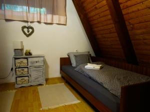 1 dormitorio con 1 cama y mesita de noche con un cajón en Wooden Cottage, en Jesenice