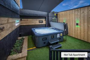 a hot tubarma sitting on the grass next to a fence at ApartHotel421 by Seafront Collection in Blackpool