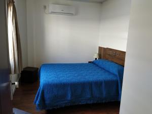 a bedroom with a blue bed with a blue blanket at Posada La Nona in Minas