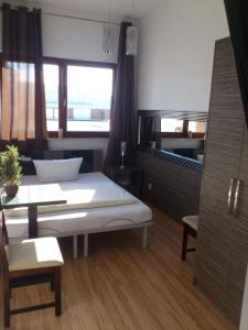 a room with a bed and a table and a window at Sky Rooms in Świnoujście