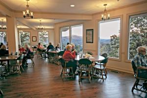 people sitting at tables in a restaurant with large windows at Pine Mountain State Resort Park in Pineville