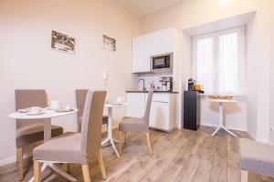 ローマにあるAzzurra Roomsのテーブルと椅子のあるキッチンとダイニングルーム