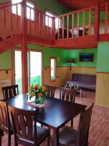 a dining room with a table and chairs and a couch at MagicPlace Neis in Villarrica
