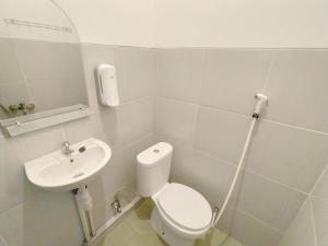 a bathroom with a toilet and a sink at Wisma Mulia Syariah Bandar Lampung in Hajimana