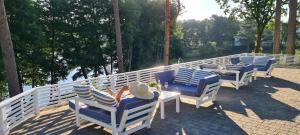 a row of chairs and tables on a patio at Przystań na Zagórzu - Apartamenty nad jeziorem in Drezdenko