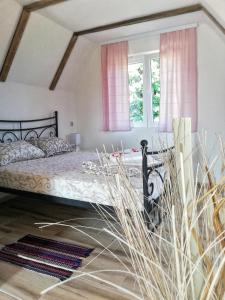 a bedroom with a bed with pink curtains at Rtanjski konak in Boljevac