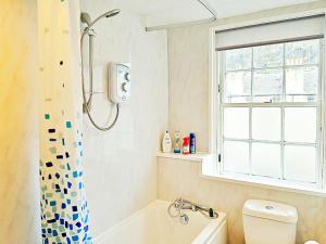 a bathroom with a tub and a toilet and a window at amazing apartments - Websters Land - Castle View in Edinburgh +20 photos
