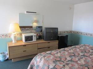 a hotel room with a bed and a tv on a dresser at Budget Inn Odessa in Odessa