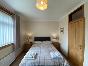 a bedroom with a bed with two towels on it at Manor House in Stornoway