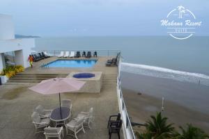 balcón con mesa y sillas y piscina en Suite Makana #403, en Tonsupa