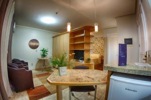 a kitchen and living room with a counter and a table at Bela Vista Hotel & Flat in Porto Alegre