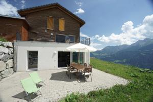 a patio with a table and chairs and a house at Clasgieri - 3-Zimmer-Ferienwohnung für 4 - 6 Personen, 65m2 in Falera