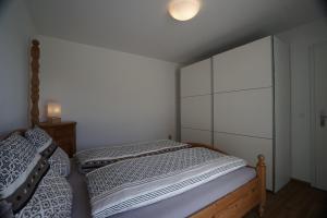 1 Schlafzimmer mit 2 Betten und einer weißen Wand in der Unterkunft Clasgieri - 3-Zimmer-Ferienwohnung für 4 - 6 Personen, 65m2 in Falera
