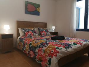 a bedroom with a bed with a colorful comforter at Brisamarina de Órzola in Orzola