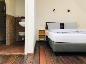 a bedroom with a bed and a bathroom with a toilet at Schiffshotel "Schlafen im Hafen" in Hamburg