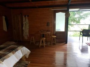 1 dormitorio con cama, mesa y ventana en Cabaña Manalí en Guatapé