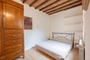 Un dormitorio con una cama y una cómoda de madera. en Luxury Home Florence terrazza vista Firenze, en Florencia
