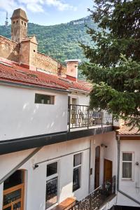 een wit gebouw met een balkon en een boom bij 1881 Brasov old town apartments in Braşov