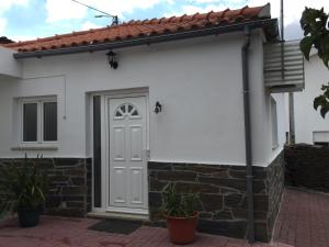 una casa blanca con una puerta blanca en Studio Bibi, en Gouvinhas