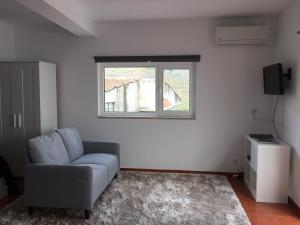 a living room with a chair and a window at Studio Bibi in Gouvinhas