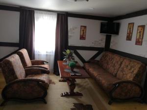 a living room with a couch and two chairs and a table at Hotel Pioner 32 in Bryansk