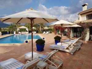 a group of chairs and umbrellas next to a pool at Boutique Hotel La Madrugada in Benissa